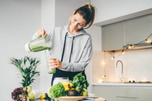 Young,Woman,Making,Detox,Smoothie,At,Home.,Woman,Pouring,Smoothie